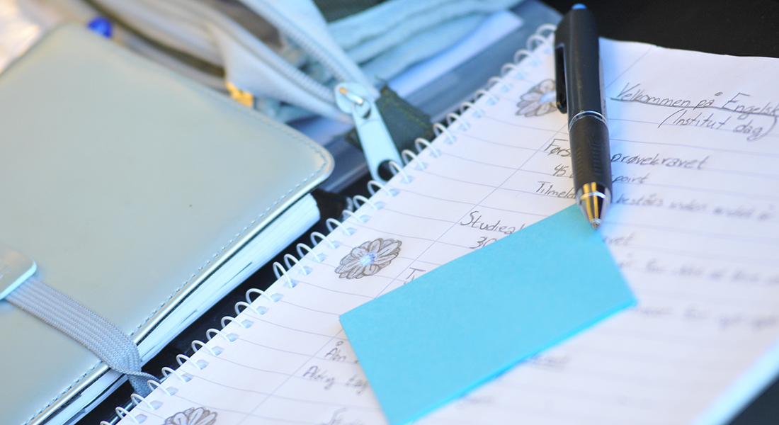 Picture of notebook, blue post-it-notes and pen